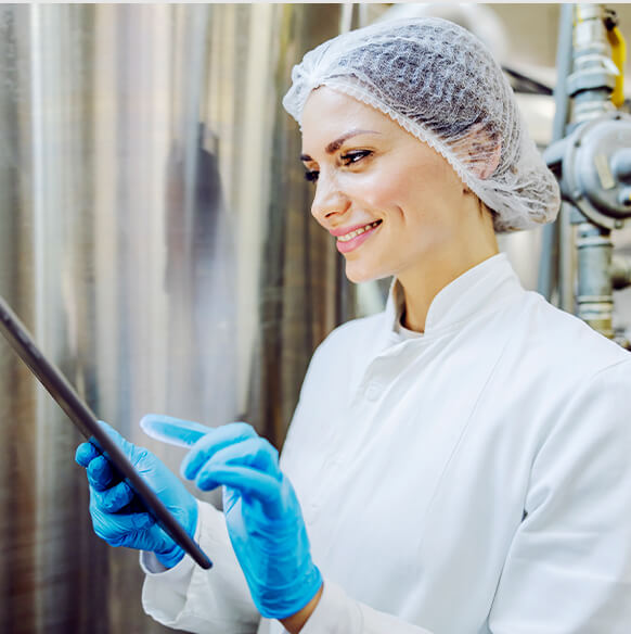 female wearing a hairnet looking at a tablet